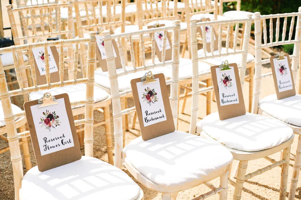 detail shot of bridesmaids reserved signs on wooden chairs