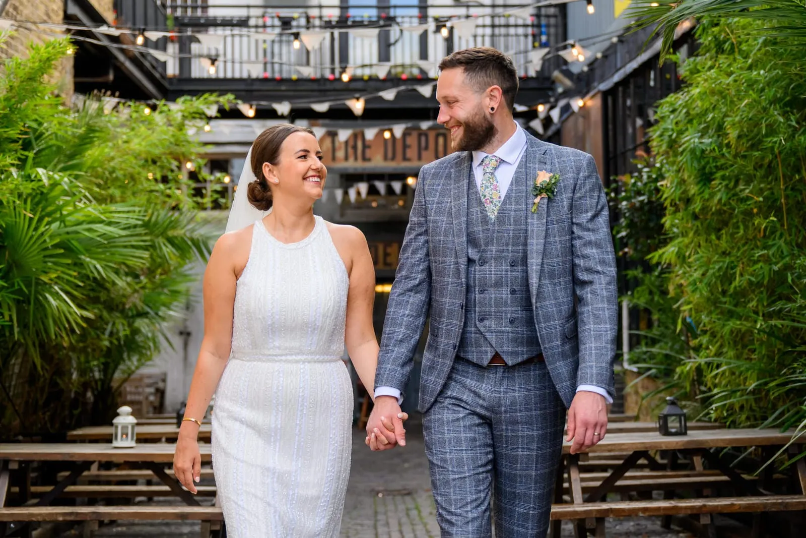 happy bride and groom holding hands in the courtyard at The Depot N7