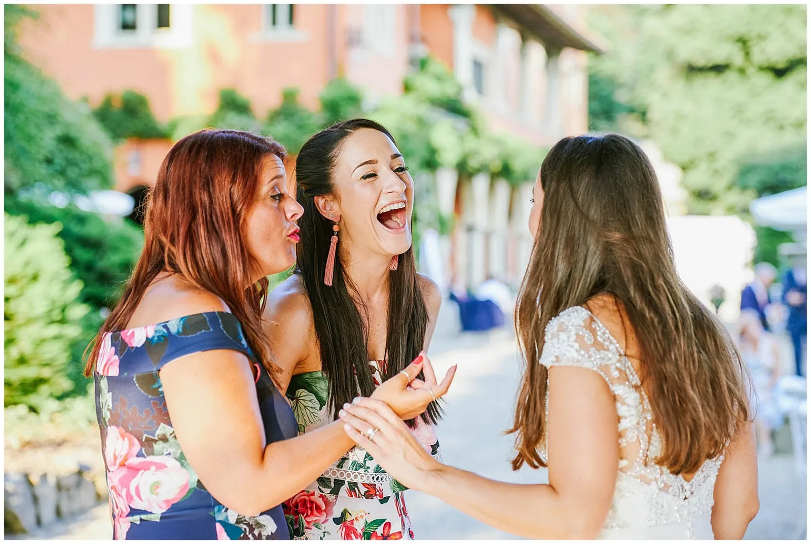 Women laughing together outside at a wedding