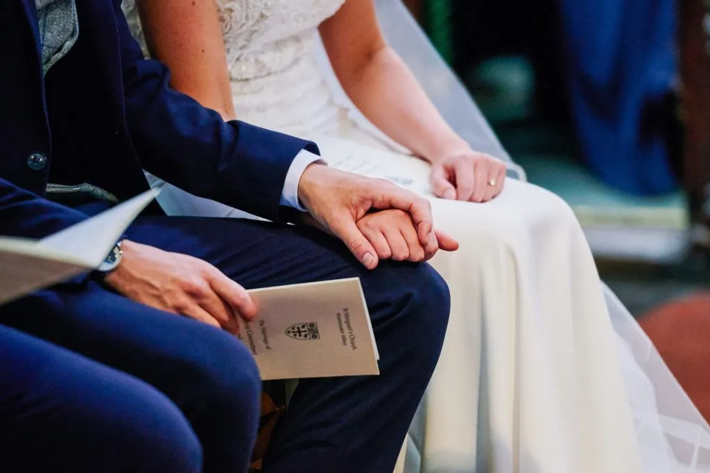 bride and groom holding hands during wedding ceremony 
