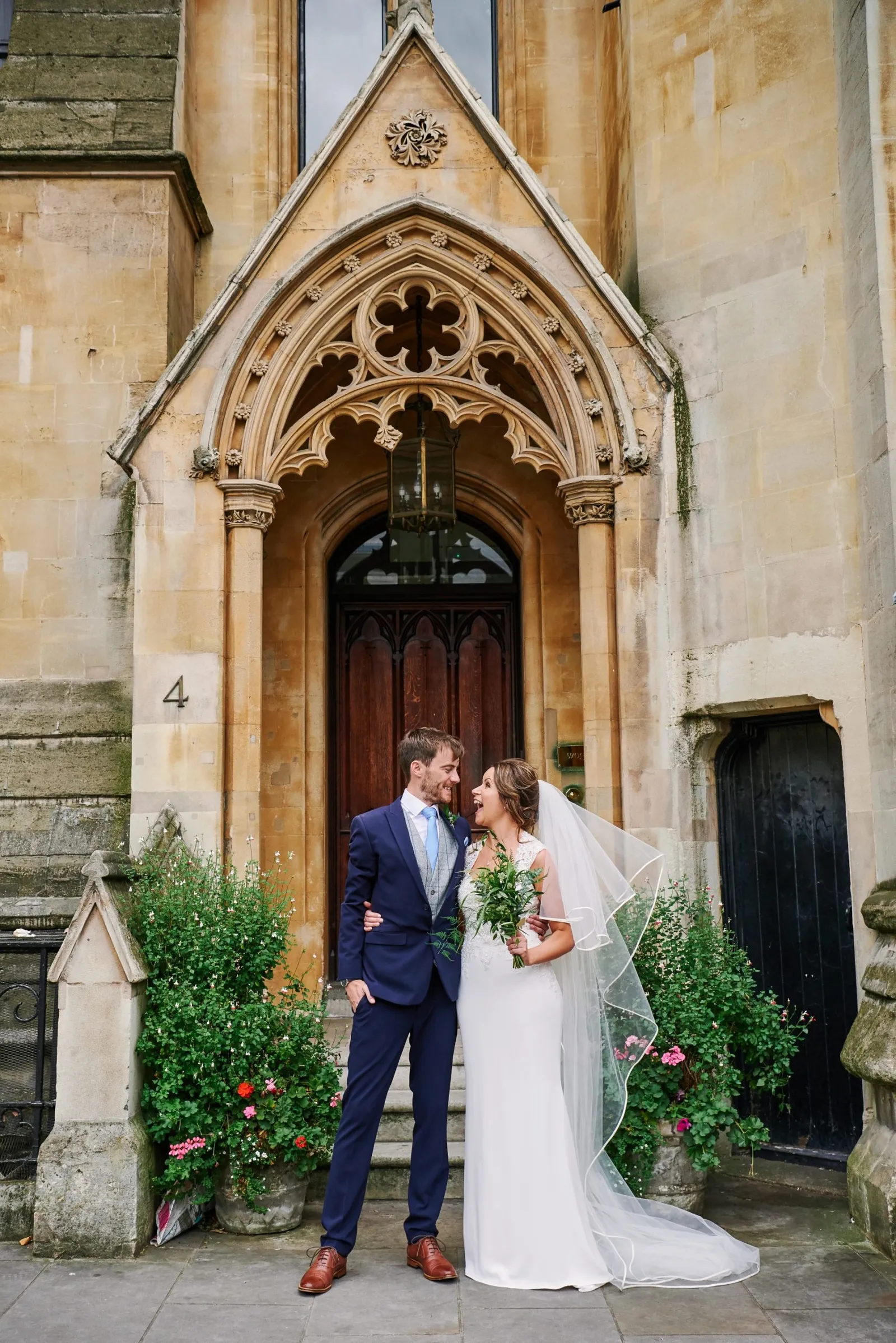 Bride and groom smiling together outside of an old doorway in London