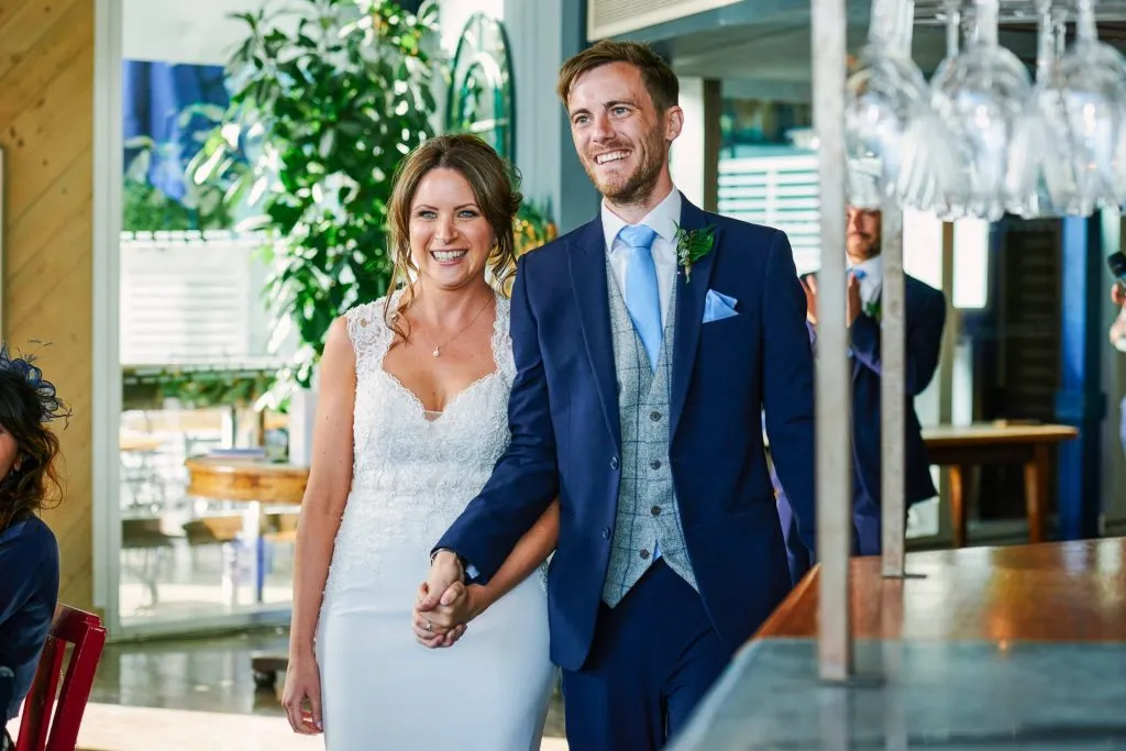 Bride and groom walking into The Oyster Shed riverside wedding venue 