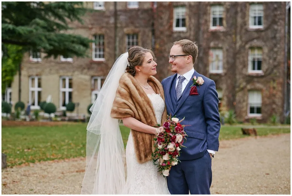 Bride and groom laughing together during winter wedding at De Vere Beaumont Estate