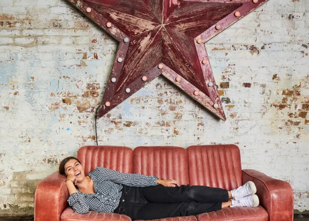 women laughing whilst lying on old couch at MC Motors Photo Studio