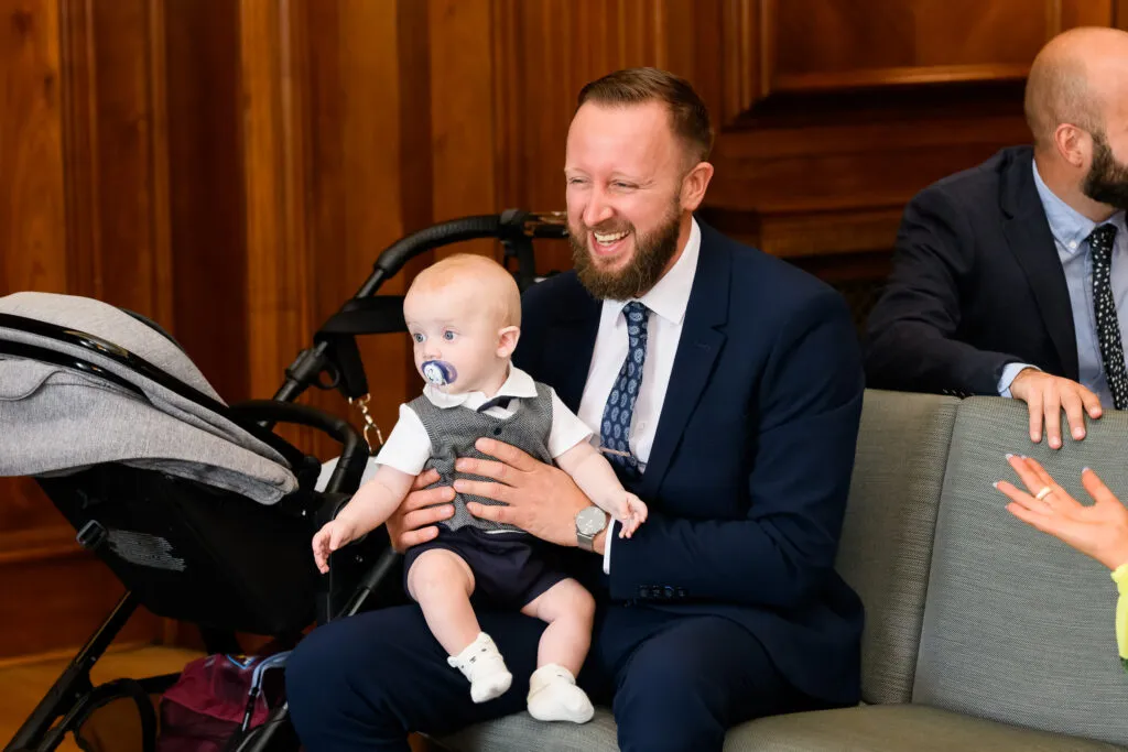 Wedding guests laughing whilst holding baby in the Westminster room 