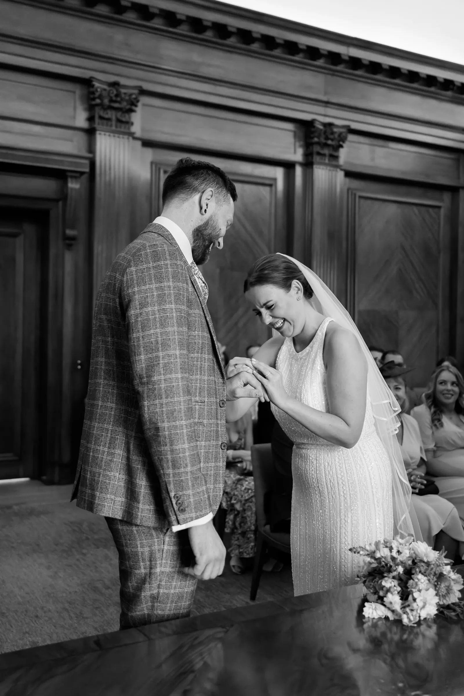 wedding couple laughing whilst exchanging rings in the Westminster room