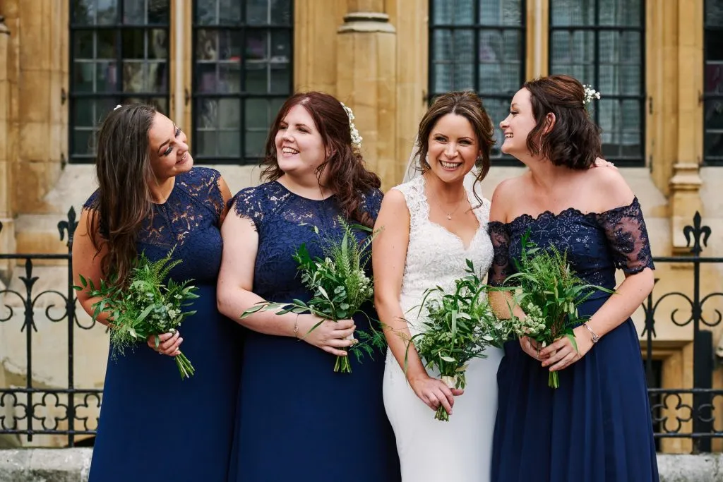 Bride laughing with her bridesmaids  outside of an old London building