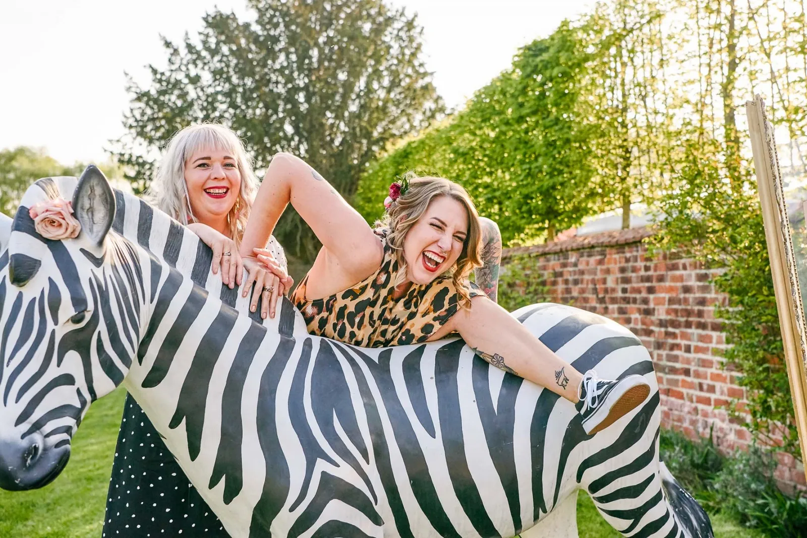 wedding guest climbing on large prop zebra during fun outdoor wedding in Nottingham
