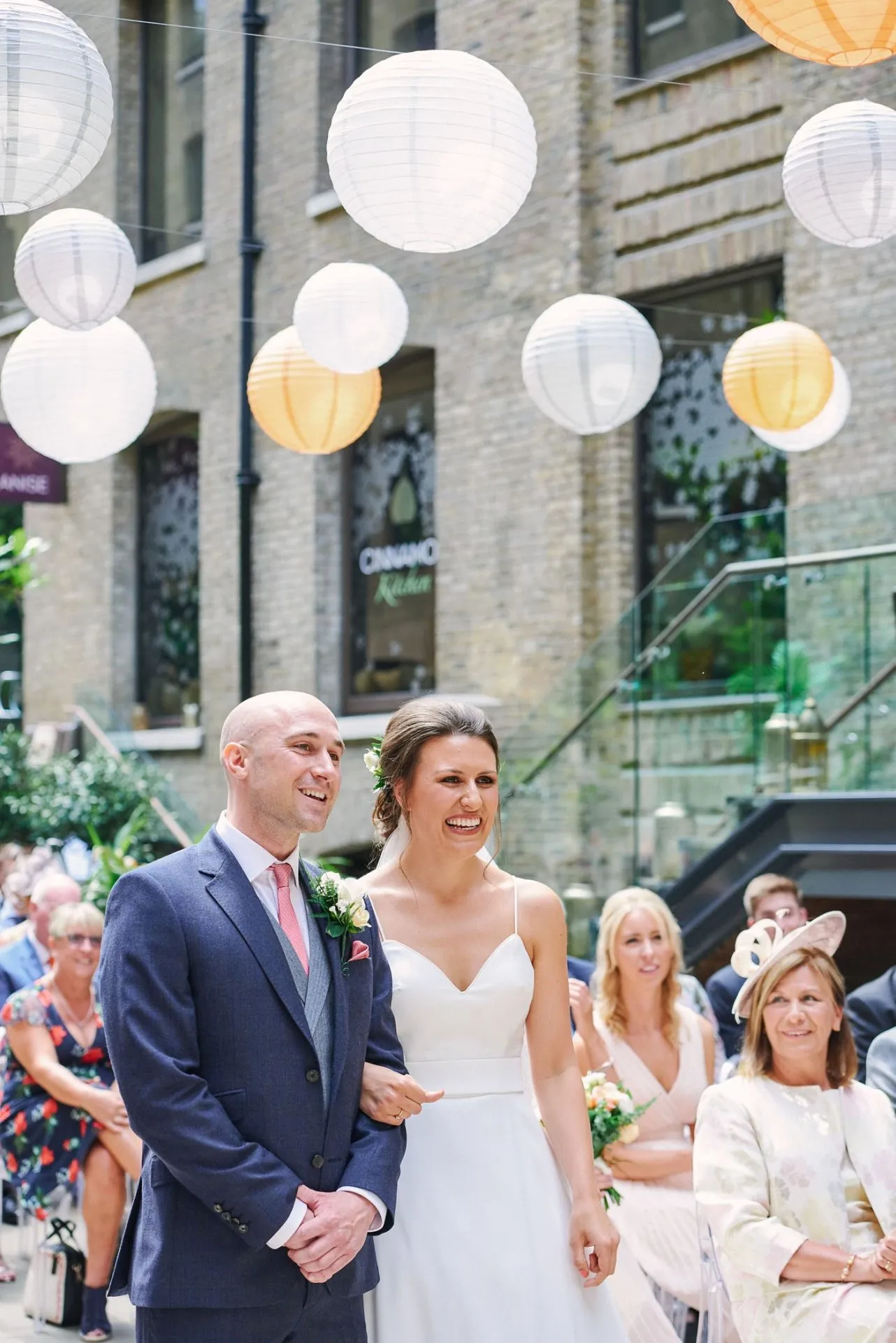 Bride and groom smiling during courtyard wedding ceremony at Devonshire Terrace in central London