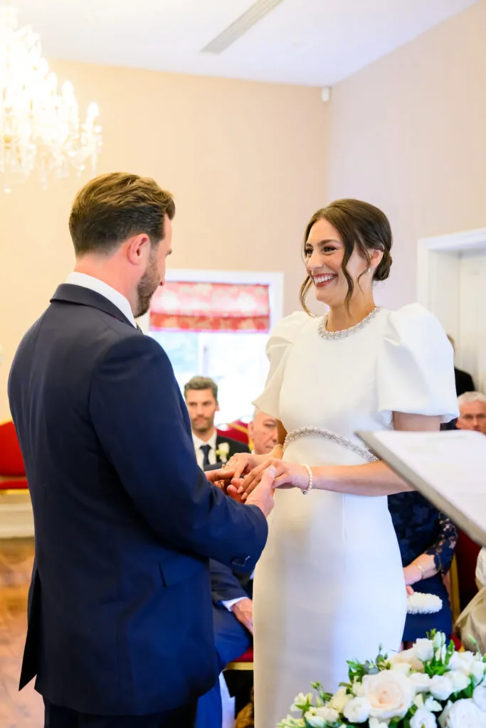 Bride placing a wedding ring on the groom’s finger during their West Bridgford ceremony