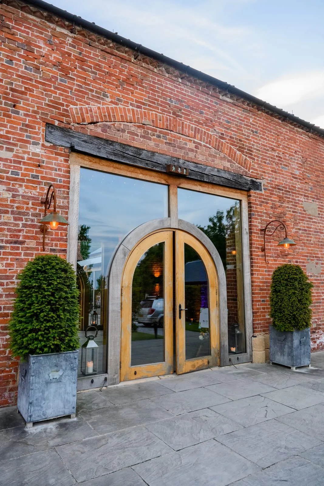 The wooden entrance doors to Hazel Gap Barn surrounded by rustic red brick
