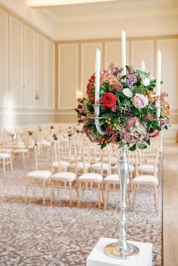 close up of flower bouquet and candle centre piece in wedding ceremony room