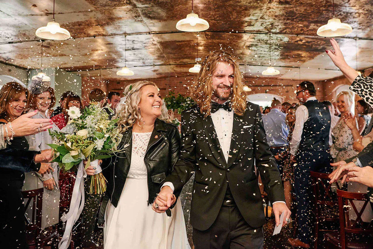 Bride and groom walking through confetti during wedding ceremony