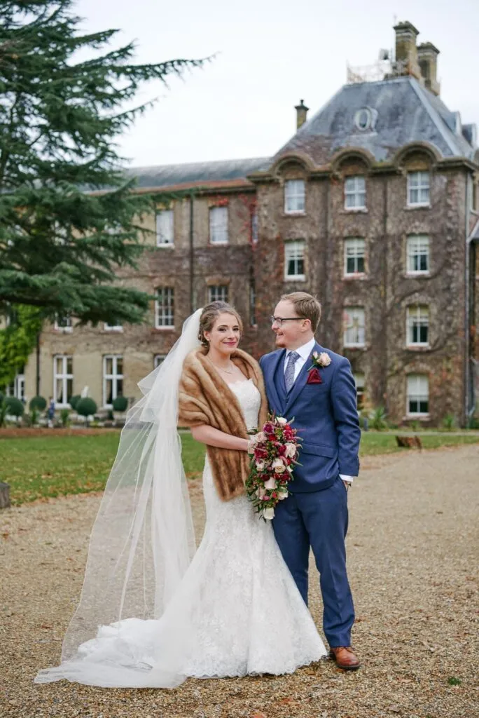 Bride and groom laughing during winter wedding at De Vere Beaumont Estate