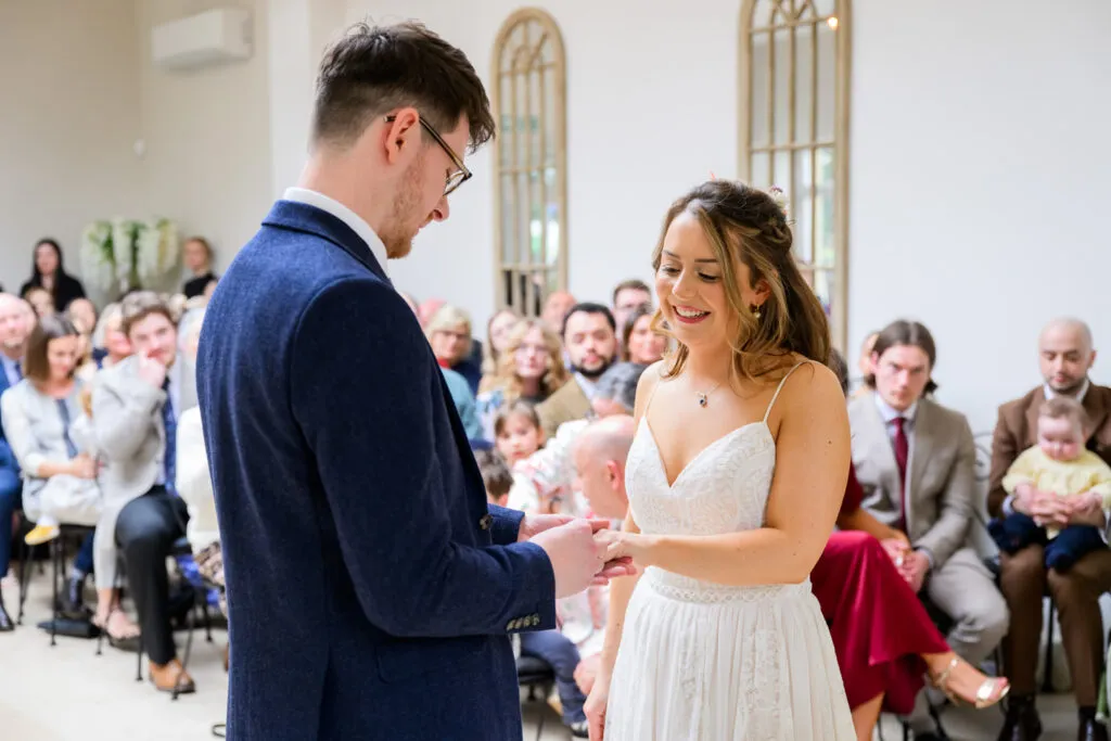 exchange of rings during woodborough hall orangery wedding ceremony